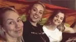 Picture of Angharad and two friends holding a rainbow flag
