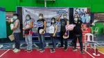 Group at vaccination centre, holding signs saying they have been vaccinated